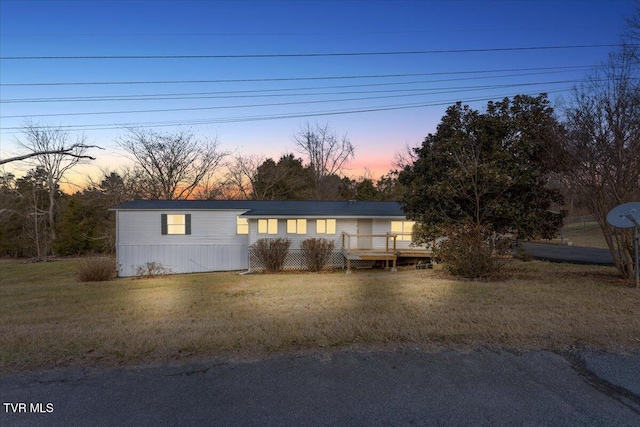 manufactured / mobile home featuring a wooden deck and a yard