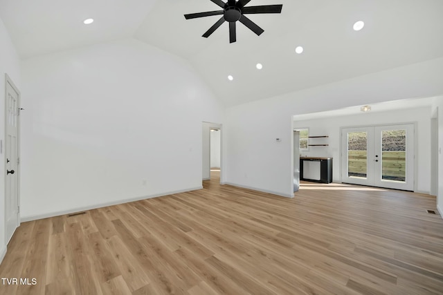 unfurnished living room with ceiling fan, light hardwood / wood-style flooring, high vaulted ceiling, and french doors