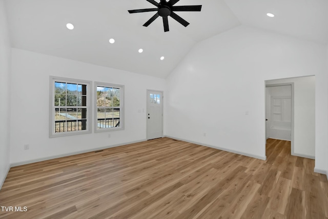 unfurnished living room featuring ceiling fan, high vaulted ceiling, and light wood-type flooring