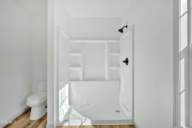 bathroom with wood-type flooring, toilet, and walk in shower