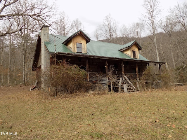 rear view of house with a yard and covered porch