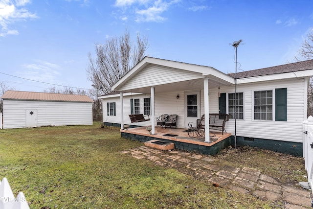 back of house with a storage unit, a patio, and a lawn