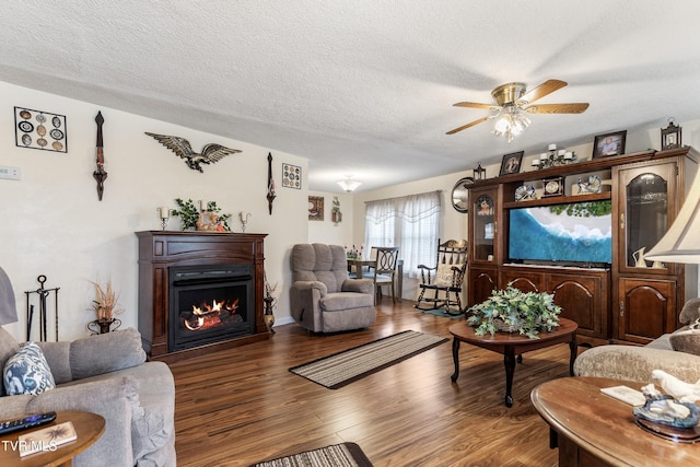 living room featuring ceiling fan, hardwood / wood-style floors, and a textured ceiling