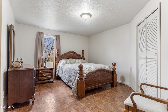 bedroom with a closet, dark parquet floors, and a textured ceiling