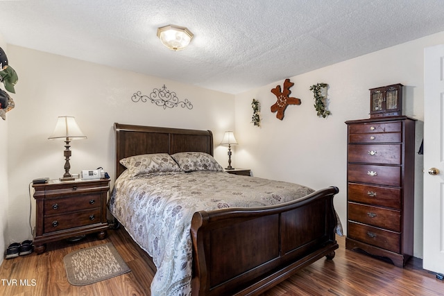 bedroom with dark wood-type flooring and a textured ceiling