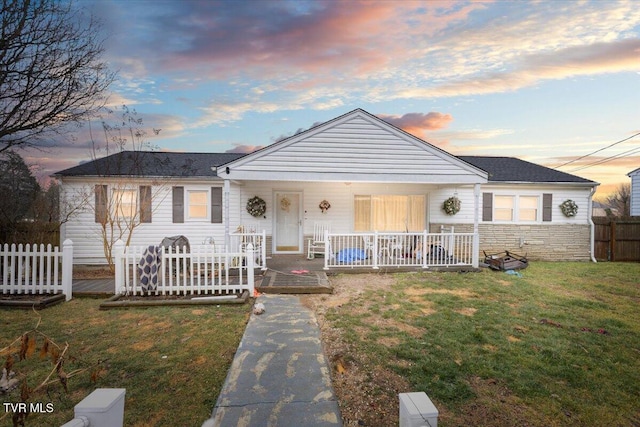 ranch-style home with a porch and a yard