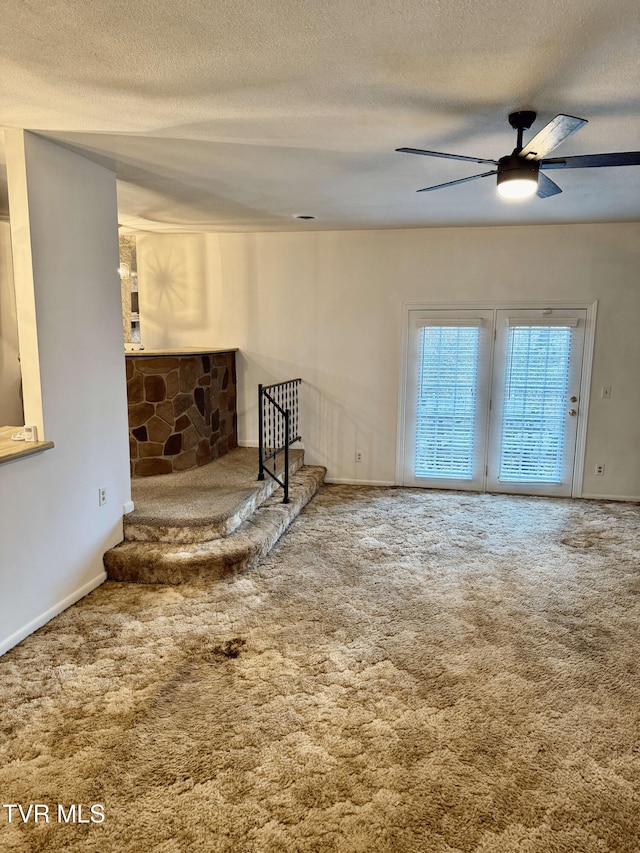 interior space with ceiling fan, carpet floors, and a textured ceiling