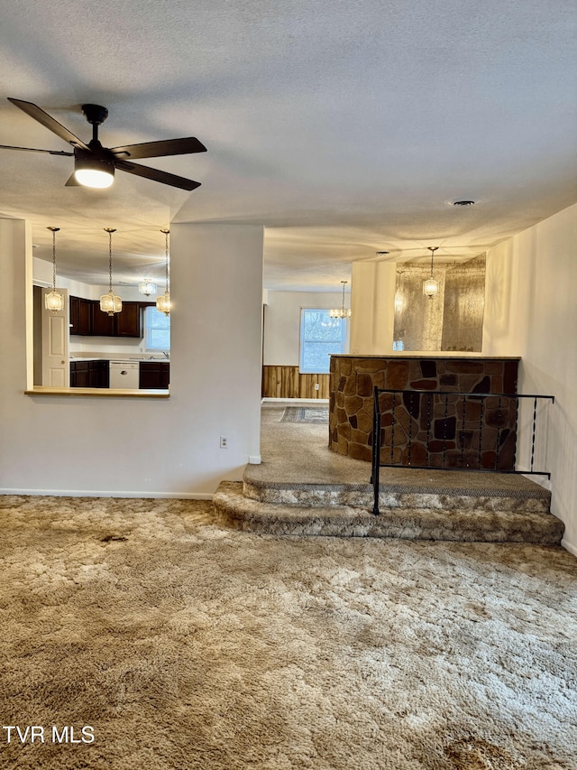 living room with ceiling fan, carpet floors, and a textured ceiling