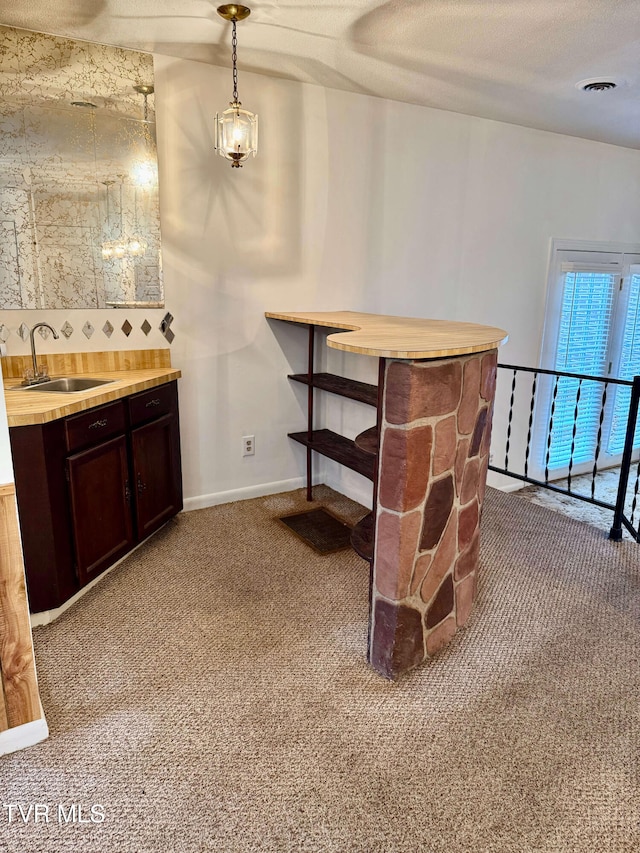 carpeted dining room with sink and a textured ceiling