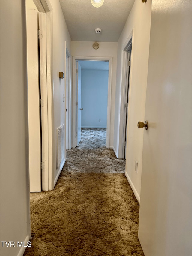 hall featuring carpet flooring