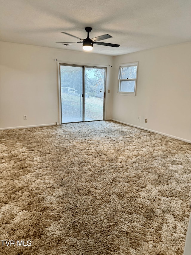 carpeted empty room with ceiling fan and a textured ceiling