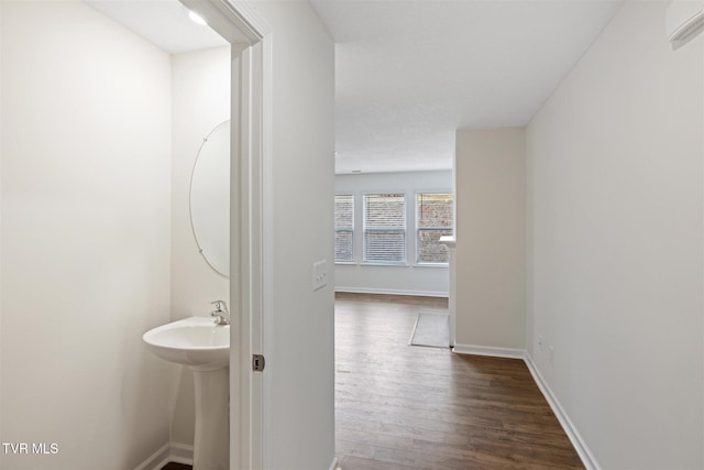 corridor featuring dark hardwood / wood-style floors and an AC wall unit