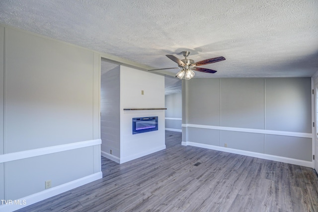 252 Scott Ln, Blountville, TN 37617 - unfurnished living room with a textured ceiling, wood finished floors, a glass covered fireplace, and a ceiling fan