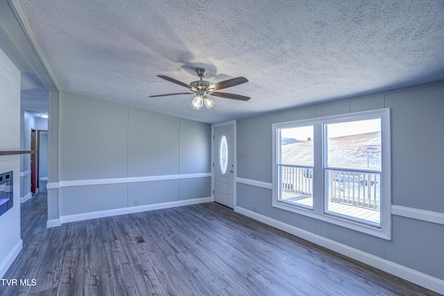 252 Scott Ln, Blountville, TN 37617 - unfurnished living room featuring a ceiling fan, baseboards, a textured ceiling, a decorative wall, and wood finished floors