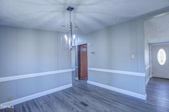 252 Scott Ln, Blountville, TN 37617 - unfurnished dining area with an inviting chandelier, a decorative wall, a textured ceiling, and wood finished floors