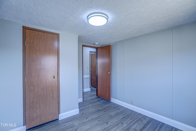 252 Scott Ln, Blountville, TN 37617 - unfurnished bedroom featuring baseboards, a textured ceiling, and wood finished floors