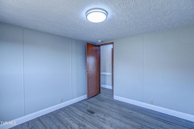 252 Scott Ln, Blountville, TN 37617 - empty room with a decorative wall, a textured ceiling, baseboards, and wood finished floors