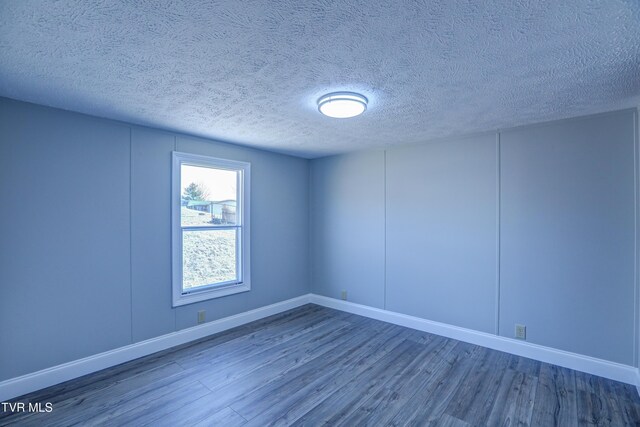 252 Scott Ln, Blountville, TN 37617 - unfurnished room featuring a decorative wall, a textured ceiling, baseboards, and wood finished floors