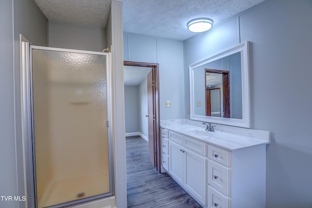 252 Scott Ln, Blountville, TN 37617 - bathroom featuring a textured ceiling, wood finished floors, a stall shower, and vanity