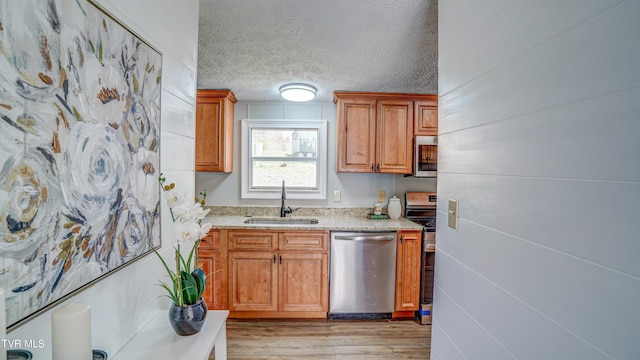 252 Scott Ln, Blountville, TN 37617 - kitchen with a textured ceiling, a sink, light wood finished floors, light stone countertops, and appliances with stainless steel finishes