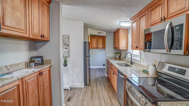 252 Scott Ln, Blountville, TN 37617 - kitchen featuring a sink, stainless steel appliances, brown cabinets, and light wood finished floors
