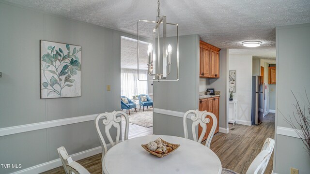 252 Scott Ln, Blountville, TN 37617 - dining space featuring a notable chandelier, a textured ceiling, baseboards, and wood finished floors