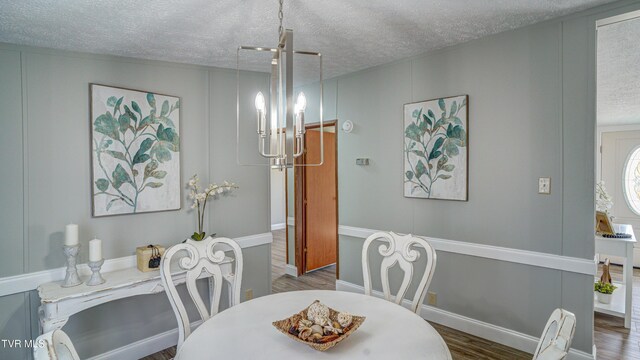 252 Scott Ln, Blountville, TN 37617 - dining area featuring a textured ceiling, wood finished floors, a decorative wall, and an inviting chandelier