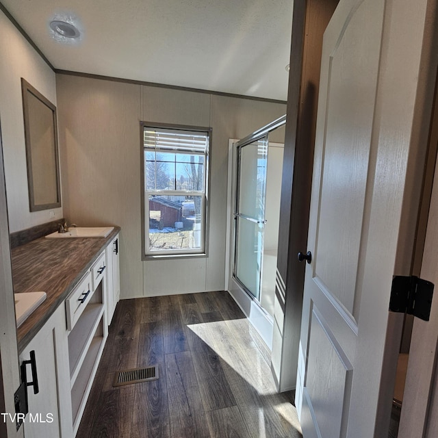 bathroom with walk in shower, vanity, crown molding, and hardwood / wood-style flooring