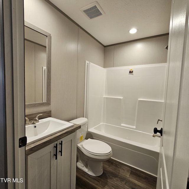 full bathroom featuring vanity, bathing tub / shower combination, hardwood / wood-style floors, and toilet