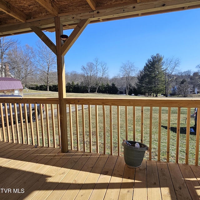 wooden terrace featuring a lawn