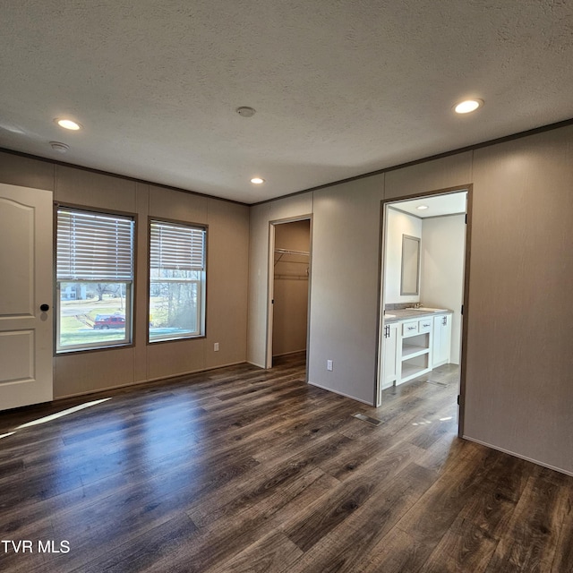 empty room with dark hardwood / wood-style flooring and a textured ceiling