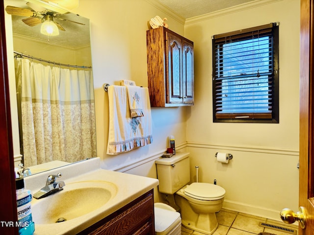 bathroom with tile patterned floors, toilet, ornamental molding, vanity, and ceiling fan