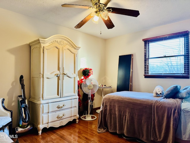 bedroom featuring a textured ceiling, dark wood-type flooring, and ceiling fan