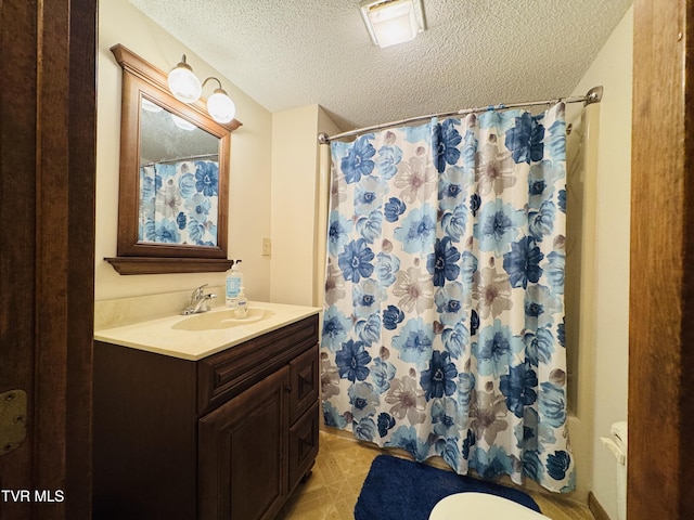 bathroom featuring vanity, walk in shower, a textured ceiling, and toilet