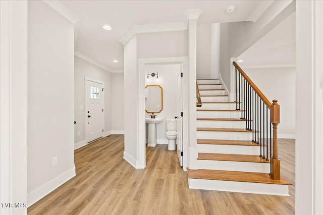 stairs featuring hardwood / wood-style flooring and ornamental molding