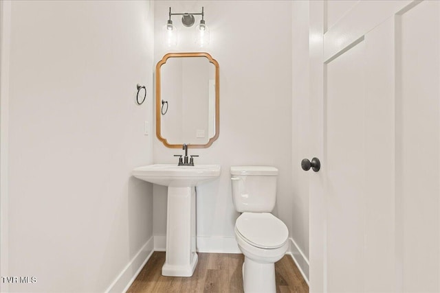 bathroom featuring hardwood / wood-style flooring, sink, and toilet