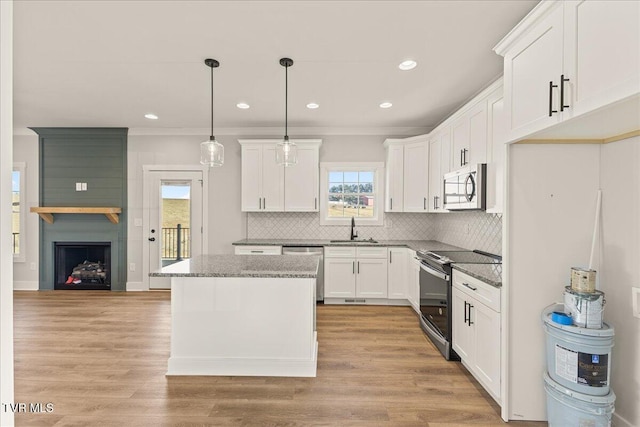 kitchen with white cabinetry, stainless steel appliances, a center island, and pendant lighting