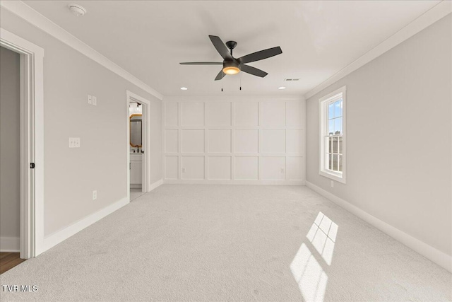 unfurnished room with crown molding, light colored carpet, and ceiling fan