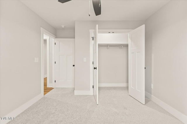 unfurnished bedroom featuring ceiling fan, a closet, and light carpet