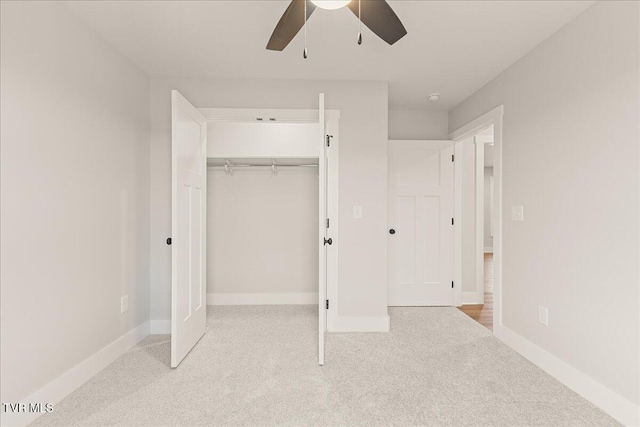 unfurnished bedroom featuring ceiling fan, a closet, and light carpet