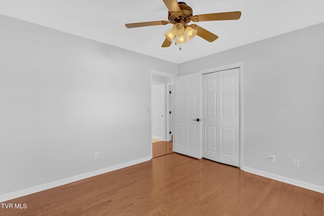 unfurnished bedroom featuring wood-type flooring, ceiling fan, and a closet