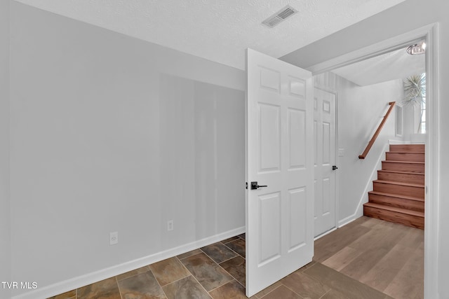 stairs with a textured ceiling