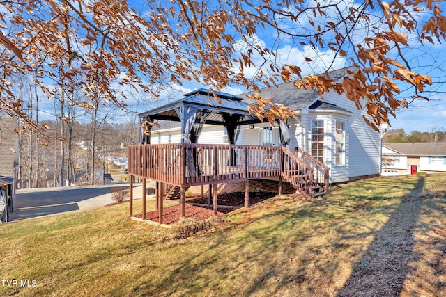 back of house featuring a gazebo, a deck, and a lawn