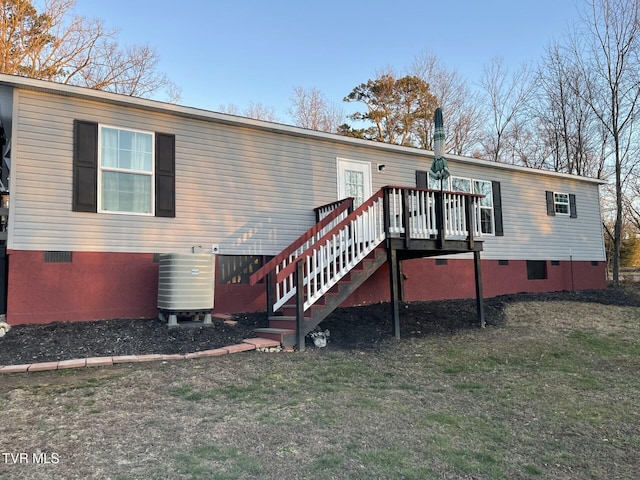 back of house with a deck, a yard, and central AC unit