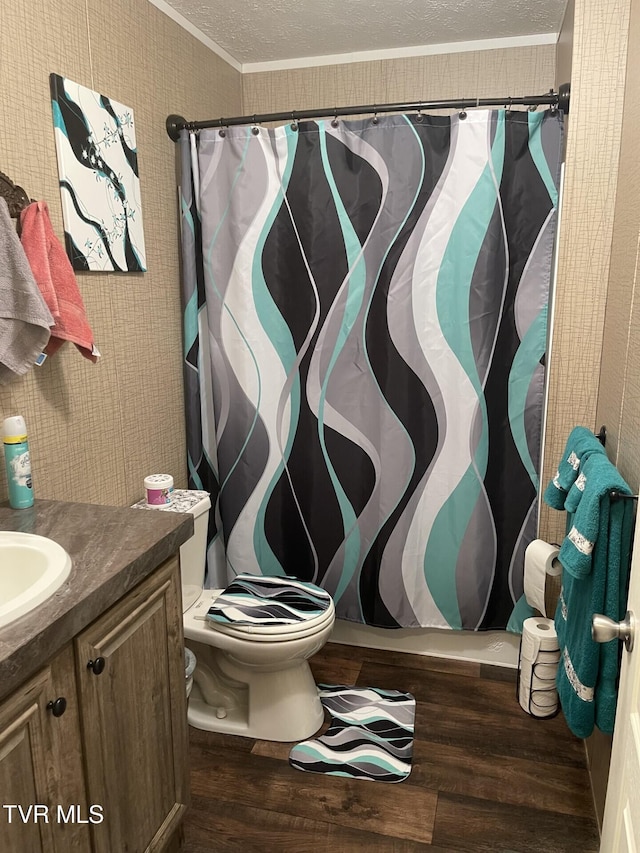 bathroom featuring crown molding, vanity, wood-type flooring, a textured ceiling, and toilet