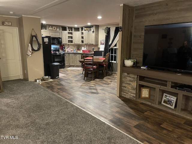 kitchen with crown molding, dark hardwood / wood-style floors, cream cabinets, and black appliances