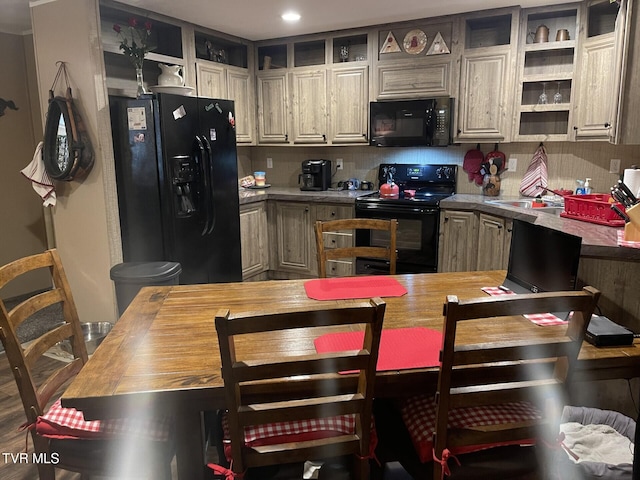 kitchen featuring butcher block counters, sink, decorative backsplash, and black appliances