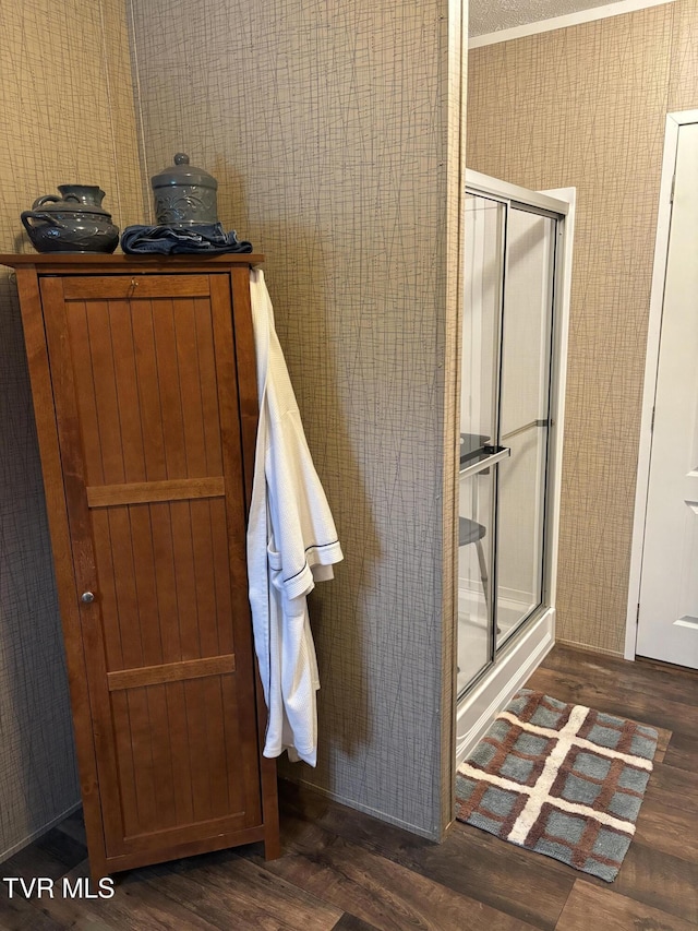 bathroom featuring hardwood / wood-style flooring and a shower with shower door