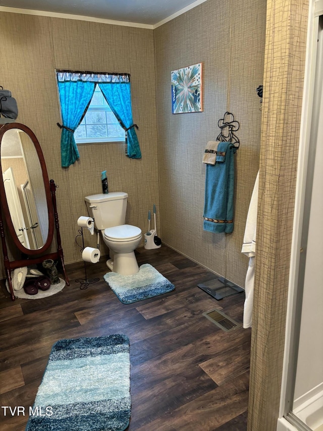 bathroom featuring ornamental molding, wood-type flooring, and toilet