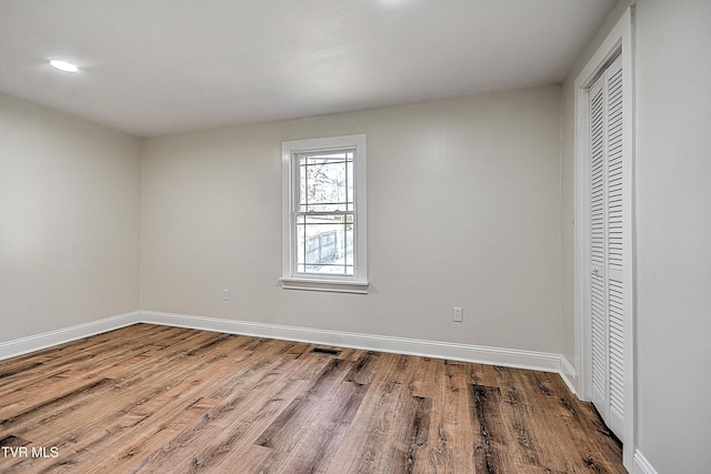 unfurnished bedroom with wood-type flooring and a closet